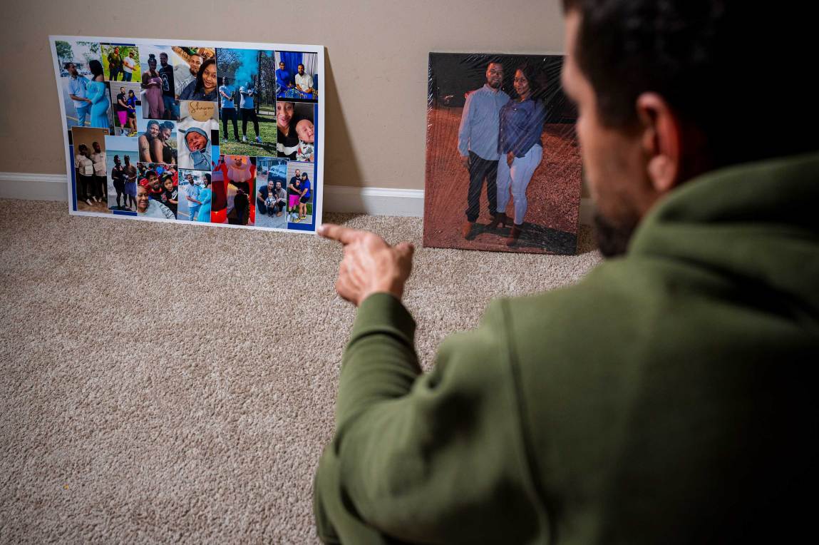 A man points at a collage of family photos next to a photo of him with his arm around a woman.