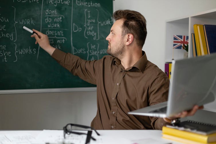 A teacher gives an English lesson using a chalkboard.