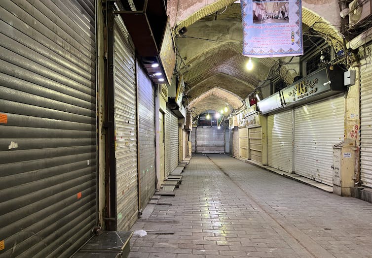 An empty indoor market shown with closed shop stalls.