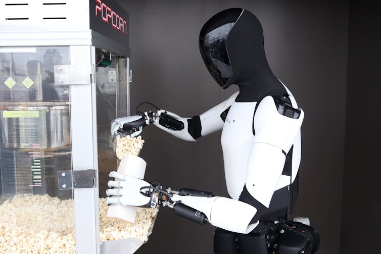 An Optimus humanoid robot serving popcorn