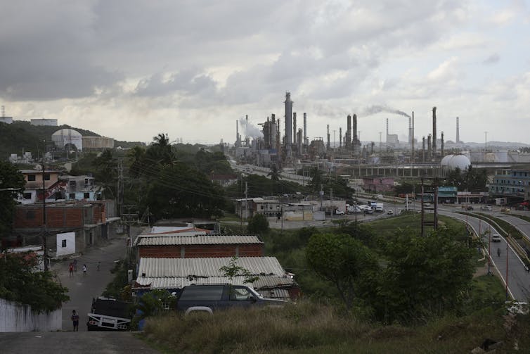A wide view shows a group of large industrial buildings with a road and other buildings nearby.