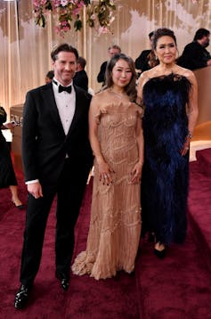 A man and two women in dressy clothes.