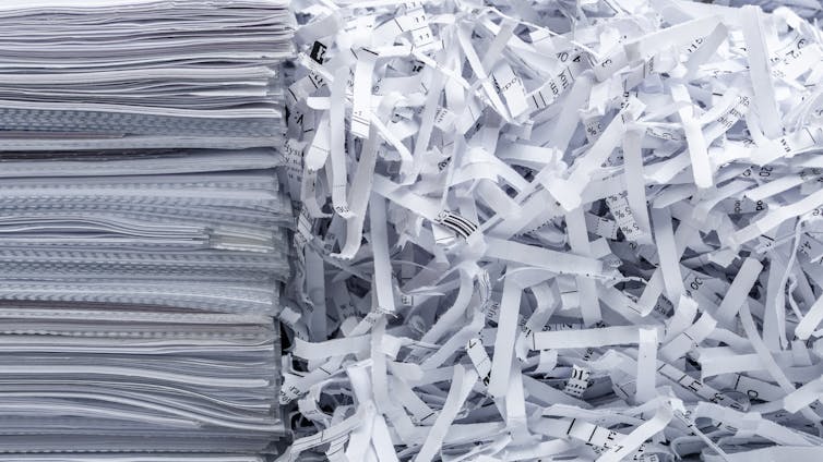 A pile of papers next to scraps from destroyed documents