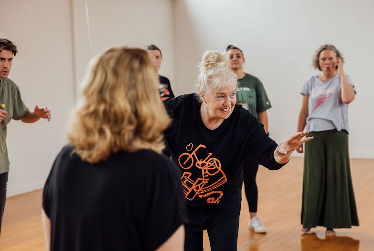 A woman with a smile runs a workshop.