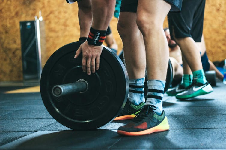 Man prepares to lift weights in a gym.