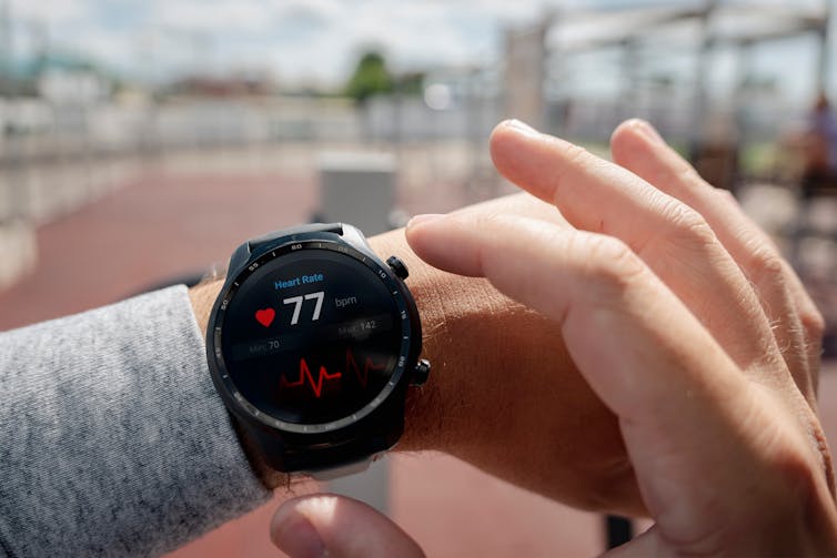 A person checks their heart rate on their wearable fitness watch.
