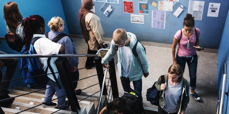 Children walking down staircase at school