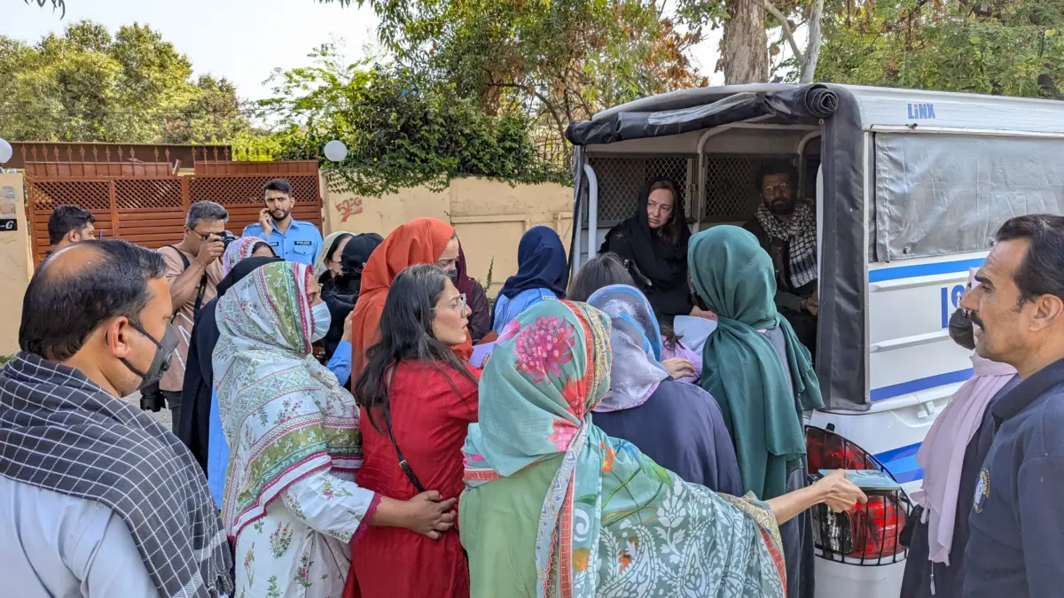Woman participants are being to be loaded in a van by the police. Image by Ramna Saeed.