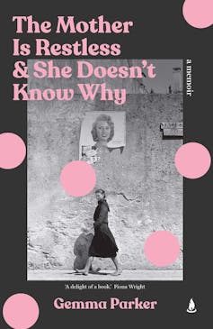 a woman in a black dress walking by a wall, pink spots over it