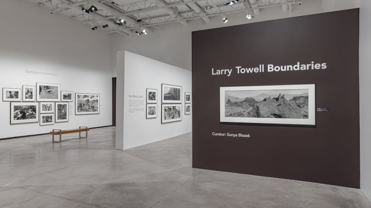 A long horizontal image of a rural landscape against a wall that says Larry Towell Boundaries.