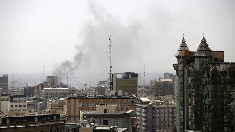 Smoke rises over a city center.