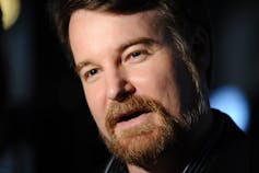 A bearded man with dark hair.