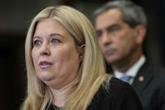 A round-faced woman with blonde hair.