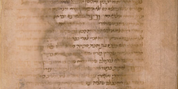 A page of an ancient manuscript with the calligraphy blurred by water damage.