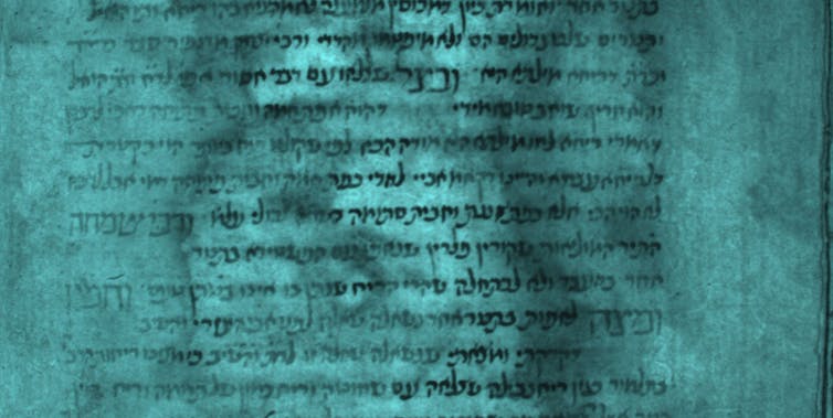 A blue-coloured page of an ancient manuscript with the calligraphy made more visible.