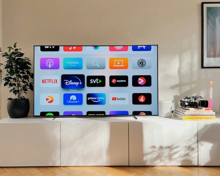 A smart TV with various subscription services on screen.