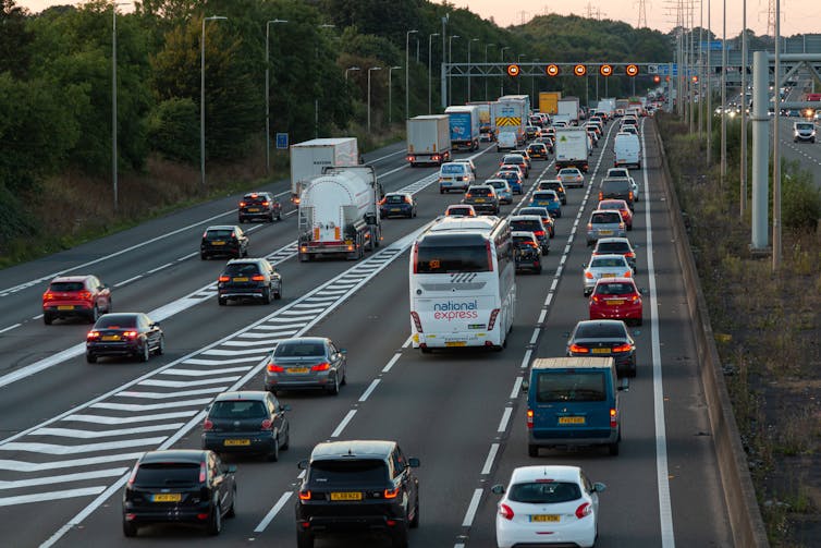rear view of cars, coaches and lorries on a busy uk motorway at dusk