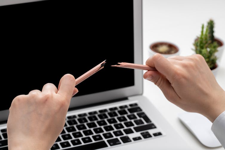 a make worker snaps a pencil over his laptop