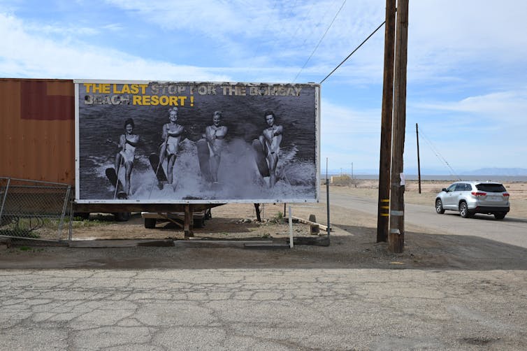 A billboard on a dusty, empty highway.
