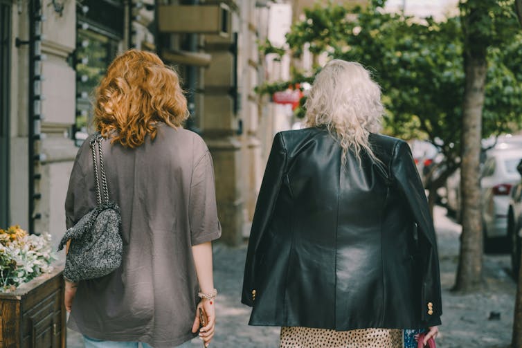 two women walk along a city street