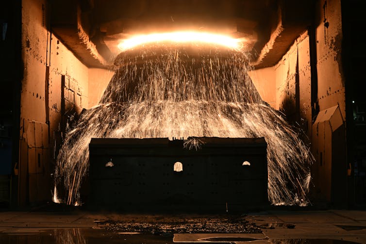 molten steel flowing from large container.