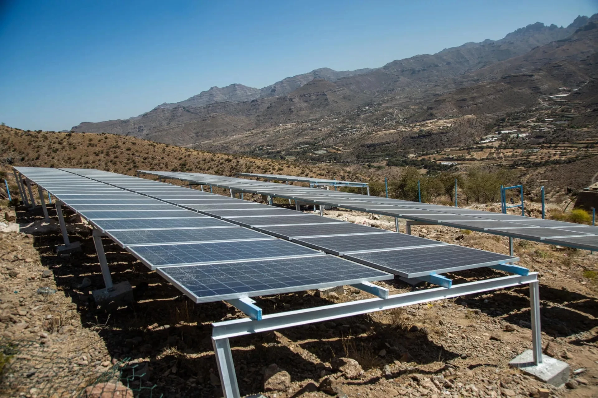 An image of solar panels charging in an arid landscape