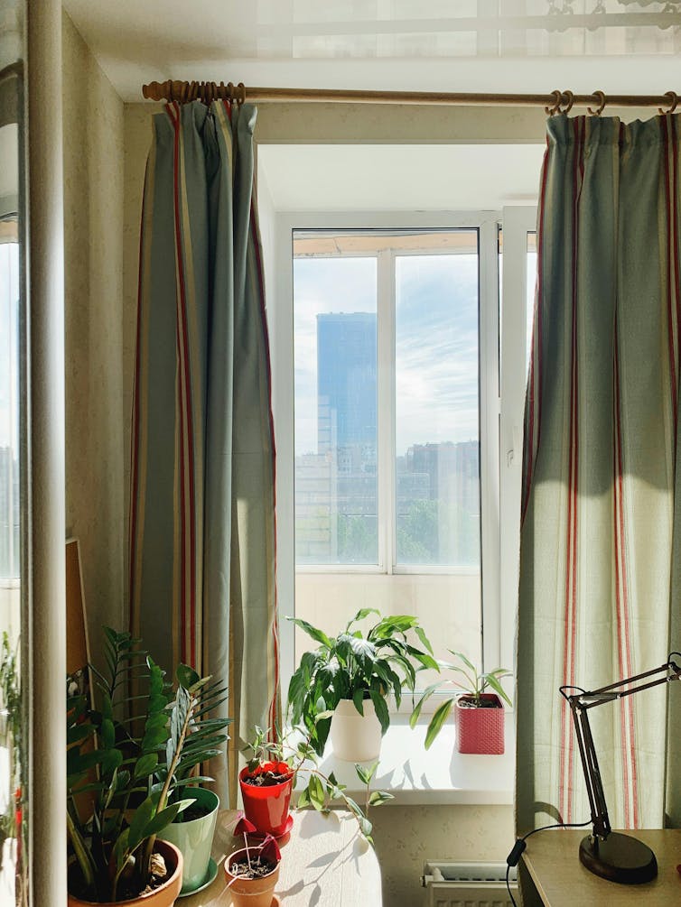 A living room with thick green curtains on the windows.