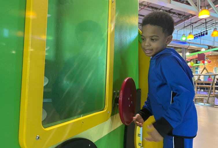 A child turns a wheel. 