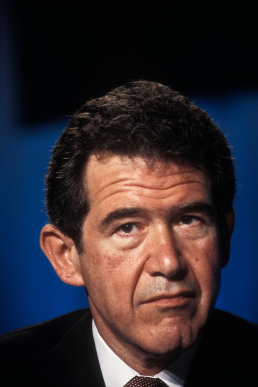 A close-up photograph of a man’s face with a serious expression. 