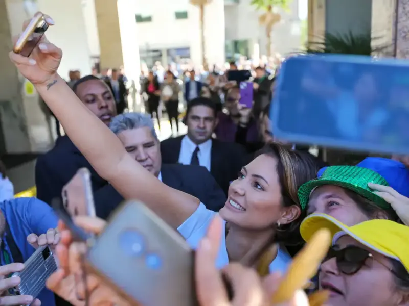 Former First Lady Michelle Bolsonaro poses with Bolsonaro's supporters in 2023, holding a cellphone to take a selfie 