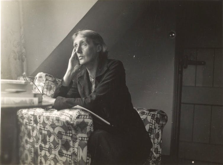 A woman sits gazing out a window.