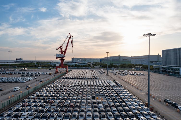 electric vehicles at a port waiting to be loaded onto a ship.