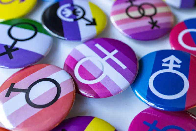 Pins displaying LGBTQ+ symbols and flags.
