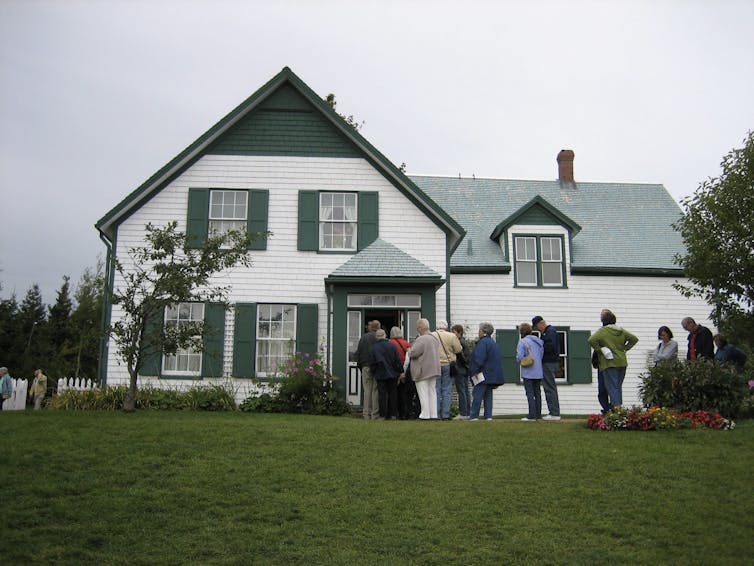 A white home with green gables.
