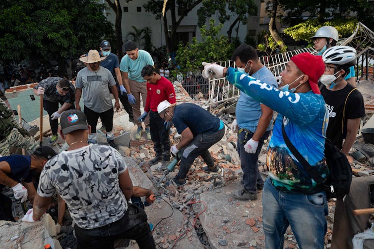 A group of Venezuelans search through rubble following two earthquakes.