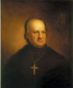A painting in dark colors shows an elderly man in a dark robe with a large cross around his neck.