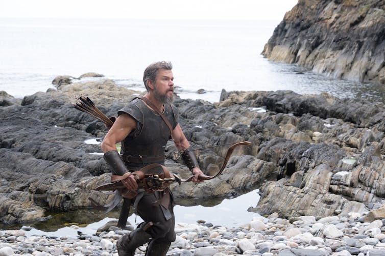 Matt Damon as Odysseus running along a rugged coast