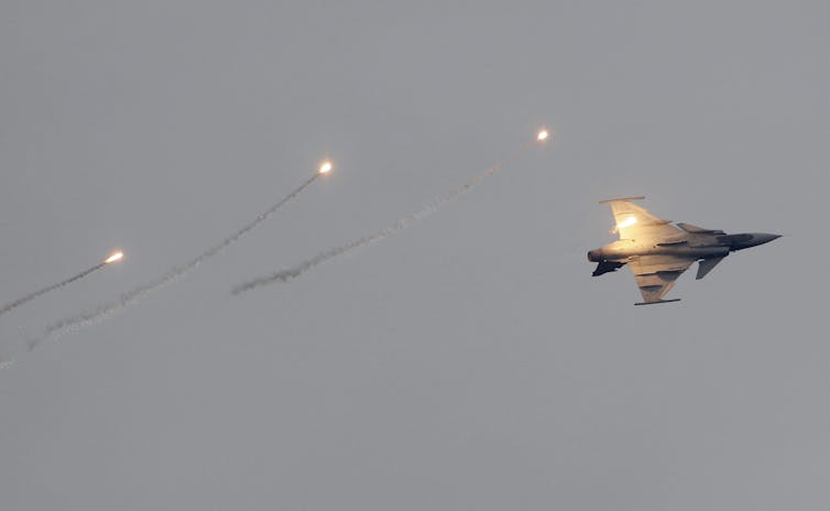 A fighter jet in a greyish sky.