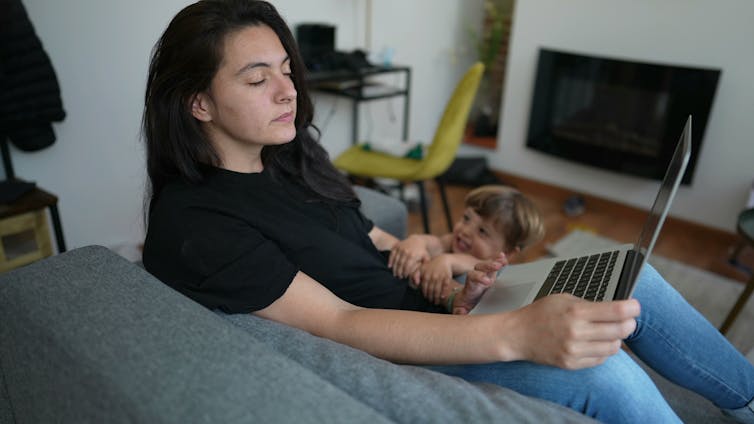Mother interrupted by child while using laptop