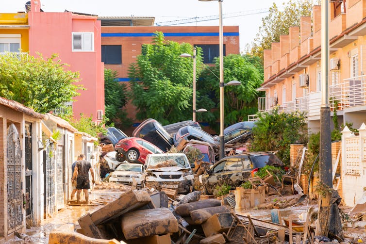 crashed cars pile up in spanish street, flood wreckage