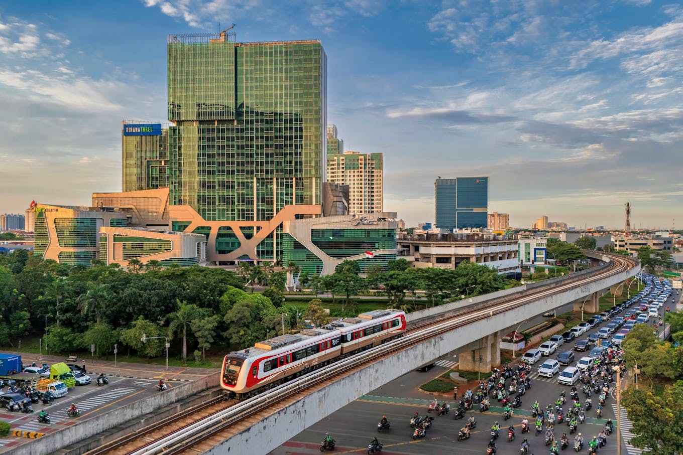 Elevated train passing through a bustling Jakarta cityscape with modern buildings