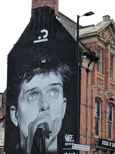 Paining of a singer on side of a building.