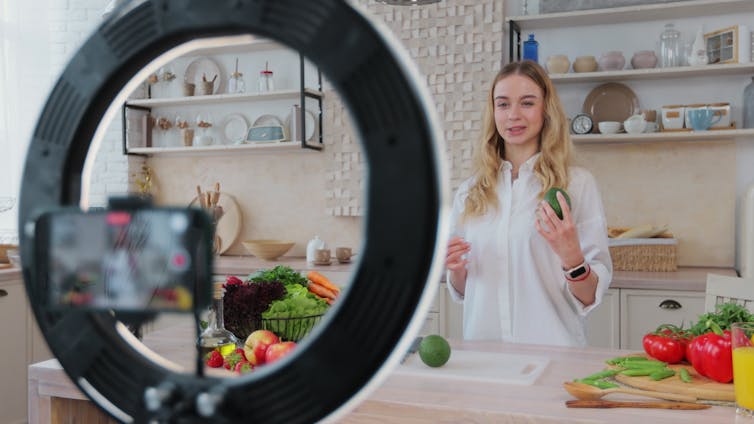 A woman filming herself cooking.