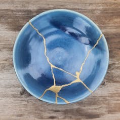blue bowl with gold repair lines, on wooden table
