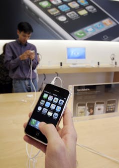 A customer examines a first-generation Apple iPhone at an Apple store in California.