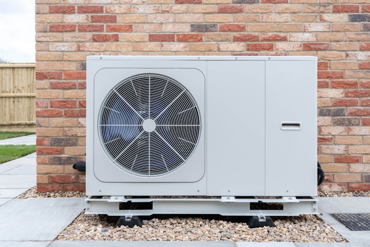 heat pump by brock wall outside of house