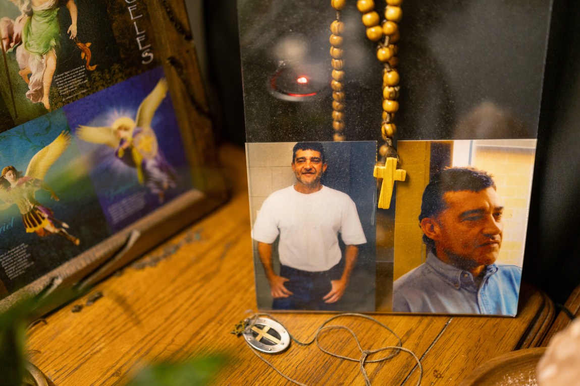 Religious items, including two crosses, and two photographs of a man in a concrete prison visitation room.