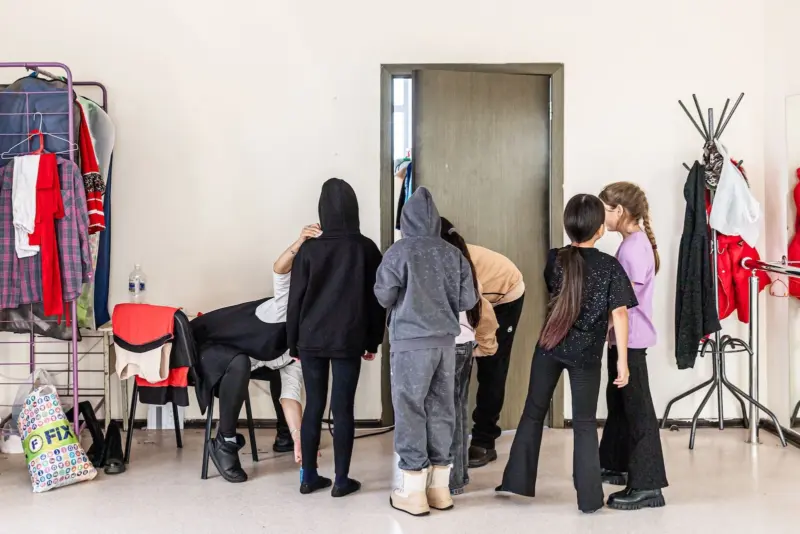 Oksana takes measurements of young dancers at the community center.