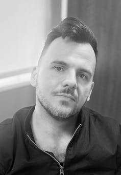 A man in a black hoodie.