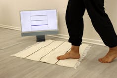 A woven area rug showing the sensor activity on a computer screen when someone is stepping on it.